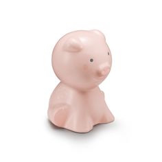 a small pink pig sitting on top of a white surface