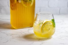 a pitcher of lemonade next to a glass filled with lemonade