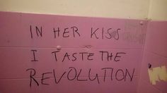 a pink wall with graffiti written on it and in her kiss i taste the revolution