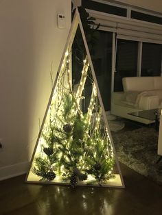 a triangle shaped christmas tree with pine cones and lights