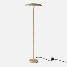 a lamp that is on top of a white surface with a cord attached to it