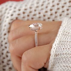 a close up of a person holding a ring with a diamond on the top and bottom