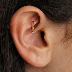 a woman's ear with a single diamond in it