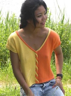 a woman standing in the grass with her hand on her hip