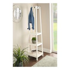 a white shelf with a coat rack and potted plant on it next to a door