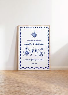 a wedding card on the floor in front of a white wall with a blue scalloped border