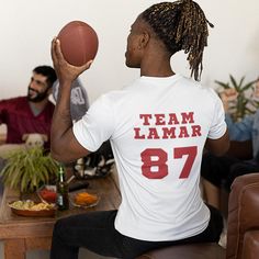 The Team Lamar 87 Super Bowl T-Shirt is a sporty and stylish gift idea for football fans, especially those who love Lamar's game. Perfect for him, this football shirt combines a love for sports with a cool, rap-inspired vibe. Whether it's for Christmas or any special occasion, this shirt says, "Not Like Us" with swagger! 𝗗𝗘𝗧𝗔𝗜𝗟𝗦: ⚡️2 Color Options - White and Red ⚡️Available in Sizes Small - 5XL ⚡️Tear-away label ⚡️Made using 100% US cotton that is ethically grown and harvested 𝗣𝗿𝗼𝗰𝗲 Super Bowl T Shirts, Funny Coworker Gifts, Rap Shirt, Christmas Gift Idea, Gifts For Office, Sport Shirt, Sports Gifts, Stylish Gifts, Football Fans