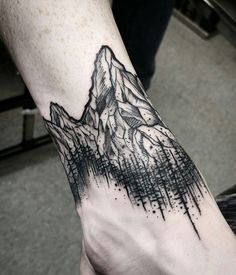 a hand with a mountain tattoo on it