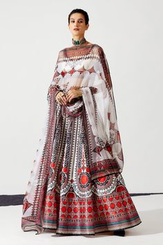 Ivory, red can-can and lined lehenga with geometric and floral print. Paired with printed blouse and printed dupatta.
Component: 3
Pattern: Printed
Type Of Work: Floral
Neckline: V Neck
Sleeve Type: Short Sleeves
Fabric: Blouse - Lycra, Dupatta - Kota Silk, Lehenga - Dupion 
Color: Ivory
Other Details: 
Geometric and floral print
Printed dupatta
Beaded borders
Back tassel tie-up
Occasion: Destination Wedding,Sangeet - Aza Fashions Ready To Wear Lehenga, Rajdeep Ranawat, Bridal Lehenga Online, Printed Lehenga, Choli Blouse, Ivory Blouse, Salwar Dress, Dress Salwar Kameez, Printed Dupatta