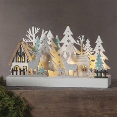 a christmas scene made out of paper with trees and reindeers in the foreground