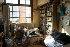 a messy living room filled with furniture and bookshelves