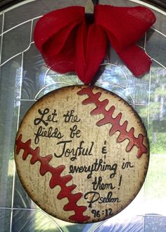 a baseball ornament with a red bow hanging from it's front door