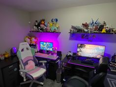 a room with two computer desks and purple lighting