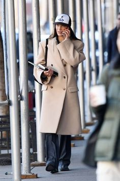 a woman walking down the street while talking on her cell phone