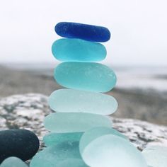 a stack of sea glass sitting on top of a rock