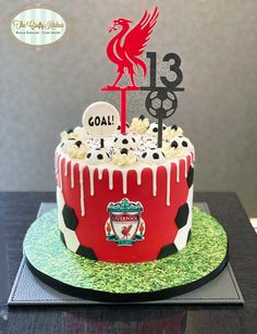 a cake decorated with soccer balls and the number 13 is on top of a table