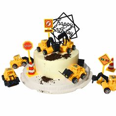 a birthday cake decorated with construction vehicles and road signs on it's side, including a stop sign