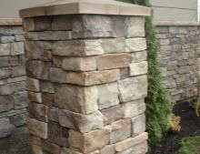 a stone pillar in front of a house