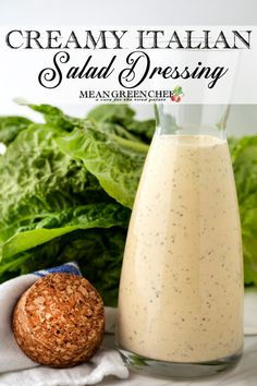 creamy italian salad dressing in a glass bottle next to a bread ball and lettuce