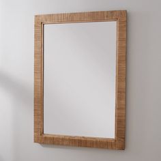 a wooden frame mirror hanging on the wall