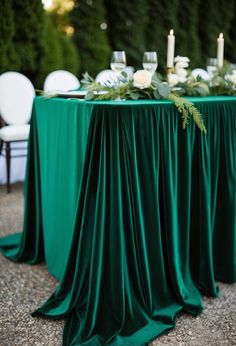 the table is set with candles and greenery for an elegant wedding reception in green