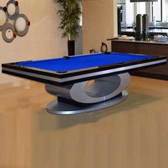 a pool table in the middle of a living room with a blue cloth on it