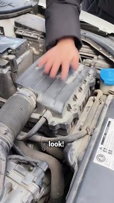 someone is working on an engine in their car, with the words look above it