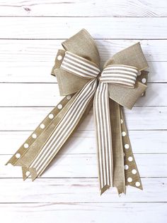 a bow with polka dots on it sitting on top of a white wooden floor next to a wall