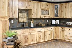 a kitchen filled with lots of wooden cabinets and counter top space next to a potted plant