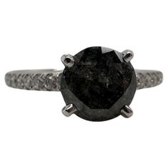 a black diamond engagement ring on a white background