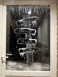 a frosted glass window with street signs in the snow and icicles on it