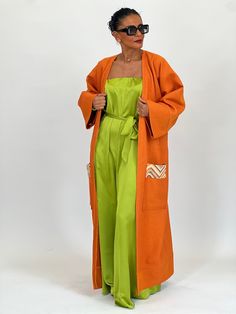 The Joranïa long kimono in bright shades of orange, embellished with a distinctive touch at the back and colorful badges on the pockets, creates a bold and personalized look, embodying individuality and creative style. Model is wearing a standard size - Model's measurement: 1m65 for a size 36 - Kimono length: 125cm *The kimonos are suitable for a 36 up to 44 *Delicate wash. Summer Cotton Outerwear With Side Pockets, Long Summer Outerwear With Pockets, Bohemian Orange Outerwear For Summer, Summer Bohemian Orange Outerwear, Spring Workwear Kimono With Kimono Sleeves, Casual Spring Kimono With Pockets, Spring Workwear Kimono, Long Sleeve Kimono With Pockets For Loungewear, Oversized Cotton Kimono With Pockets