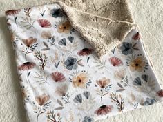 a blanket with flowers on it laying on the floor