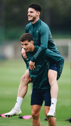 two soccer players are hugging each other on the field