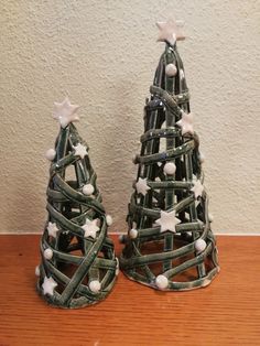 two small christmas trees made out of plastic wrapped in string and decorated with white stars