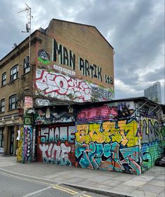 a building covered in graffiti next to a street