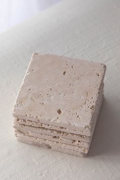 a stack of small pieces of concrete sitting on top of a white table covered in dirt