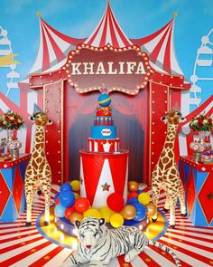 a circus themed birthday cake with giraffes and balloons in front of it