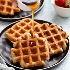 syrup being poured on top of two waffles