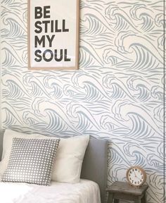 a bedroom with a bed, nightstand and wallpaper that says be still my soul