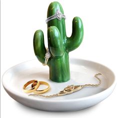 a green cactus with two gold rings on it and a diamond ring in the middle