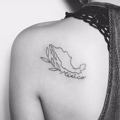 a black and white photo of a woman's shoulder with a tattoo on it