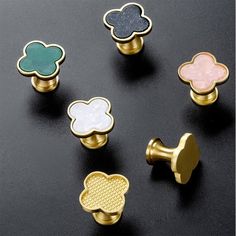 six different types of knobs on a black surface, each with four different colored flowers