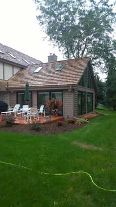 a house with lawn chairs and an umbrella