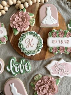 some decorated cookies are on a wooden platter next to eggs and flowers with the word love spelled in cursive