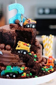 a birthday cake that is shaped like a truck and dump truck with the number two on top