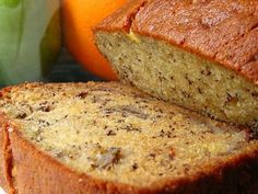 a loaf of banana bread sitting on top of a white plate next to an orange