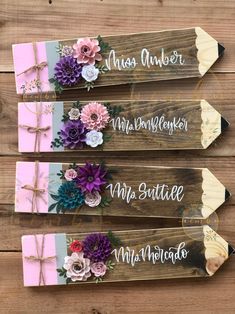 three wooden signs with flowers on them