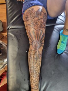 a person with tattoos on their legs sitting in a chair