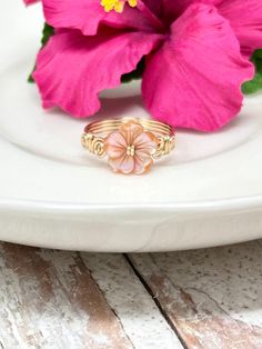 a pink flower sitting on top of a white plate